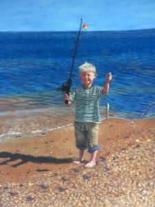 Boy holding fishing pole and small fish with lake behind him