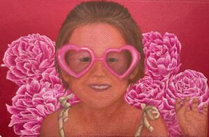 young girl in pink heart glasses with pink roses in background on red paper